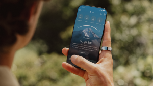 Hombre sosteniendo un teléfono que muestra la aplicación Oura mientras lleva puesto el anillo