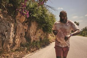 man running while checking his Fitbit