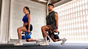 Man and woman lifting kettle bells