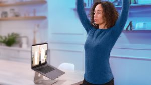 woman stretching while watching laptop