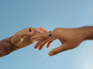 Hands touch each other wearing rings.