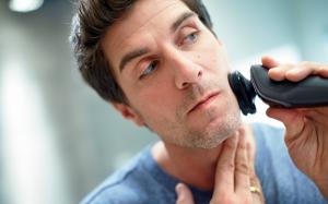 Man shaving with electric razor